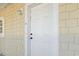 White front door with sidelight and exterior light fixture against light yellow siding at 110 South Shore Blvd. # 302, Longs, SC 29568