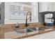 Close-up of a kitchen sink with granite countertops and a modern black faucet near a bright window at 110 South Shore Blvd. # 302, Longs, SC 29568