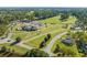 Aerial view of golf course, clubhouse, surrounding neighborhood with mature trees and landscaping at 1205 Woodruff Ct., Conway, SC 29526