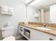 Bright bathroom featuring granite countertop vanity, white cabinets, toilet, and mirror at 1207 S Ocean Blvd. # 20206, Myrtle Beach, SC 29577