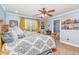 Comfortable bedroom features a patterned bedspread, ceiling fan, and lots of natural light, creating a cozy and inviting space at 1888 Singing Pines Dr., Conway, SC 29527