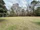 Spacious backyard features a vast lawn and mature trees, offering a serene and private outdoor space at 1993 Meadowood Ln., Longs, SC 29568