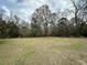 Expansive backyard offers a large grassy area bordered by mature trees, providing a private outdoor space at 1993 Meadowood Ln., Longs, SC 29568