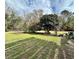 Green backyard with mature shade trees offering lots of room for outdoor activities at 1993 Meadowood Ln., Longs, SC 29568
