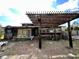 Home exterior features a pergola, brick patio, and rustic wood paneling, set in a spacious backyard at 1993 Meadowood Ln., Longs, SC 29568
