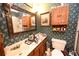 Cozy bathroom with floral wallpaper, wood cabinets, and a shower at 1993 Meadowood Ln., Longs, SC 29568