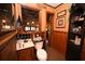 Traditional bathroom featuring a sink, toilet and mirror with wood cabinets and floral wallpaper at 1993 Meadowood Ln., Longs, SC 29568
