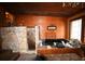 Relaxing bathroom featuring a jacuzzi tub with stone accents and wood paneling for a rustic aesthetic at 1993 Meadowood Ln., Longs, SC 29568