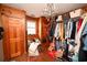Walk-in closet is equipped with shelves and hanging rods, offering ample storage space and a chandelier at 1993 Meadowood Ln., Longs, SC 29568