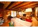Warm living room showcasing a brick fireplace, beamed ceiling, and wooden walls at 1993 Meadowood Ln., Longs, SC 29568