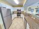 Bright kitchen with white cabinets, stainless steel appliances, and granite countertops with bar seating at 2007 S Ocean Blvd. # 204, Myrtle Beach, SC 29577