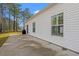Concrete patio off the back of the home with views of the lush, green lawn and tall trees at 2015 Borgata Loop, Longs, SC 29568
