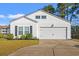 Charming single-Gathering home boasts a bright white exterior, a two-car garage, and professional landscaping at 2015 Borgata Loop, Longs, SC 29568