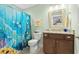 Colorful bathroom features a vanity with granite countertop, tropical shower curtain, and neutral walls at 205 Deep Blue Dr., Myrtle Beach, SC 29579