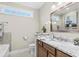 Bathroom vanity features a marble countertop, dark wood cabinets, a sink and a decorative mirror at 205 Deep Blue Dr., Myrtle Beach, SC 29579
