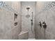 A tiled walk-in shower features a tiled accent strip, a built-in niche, and dual shower heads at 205 Deep Blue Dr., Myrtle Beach, SC 29579