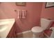 Clean half-bathroom featuring pink walls, a white toilet, and a wood vanity at 210 25Th Ave. S # 26, Myrtle Beach, SC 29577
