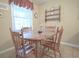 Inviting dining area with a round wood table, four chairs, and ample natural light from the window at 210 25Th Ave. S # 26, Myrtle Beach, SC 29577