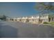 Exterior view of a row of townhomes with brick accents and ample parking space in front at 210 25Th Ave. S # 26, Myrtle Beach, SC 29577