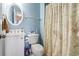 Well-lit bathroom with blue walls, toilet, vanity and a textured shower curtain at 2304 Pointe Marsh Ln., North Myrtle Beach, SC 29582