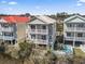 Exterior angle showing multiple balconies and ground level patio of a beach house near the coast at 2304 Pointe Marsh Ln., North Myrtle Beach, SC 29582