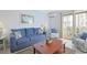 Comfortable living room featuring a plush sofa and access to a screened in outdoor space at 2405 S Ocean Blvd. # 105, North Myrtle Beach, SC 29582