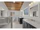 This bathroom features double sinks, marble counters, shower and bathtub with wood planking on the ceiling at 288 Rum Gully Rd., Murrells Inlet, SC 29576