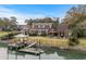 Stunning waterfront home featuring a private dock, manicured lawn, and outdoor seating area at 288 Rum Gully Rd., Murrells Inlet, SC 29576
