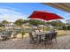 Outdoor patio featuring a dining set with red umbrella, waterfront view, and lush landscaping at 288 Rum Gully Rd., Murrells Inlet, SC 29576