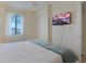 Bedroom features a mounted TV, and a window with blinds providing natural light at 301 N Waccamaw Dr. # 209, Garden City Beach, SC 29576