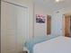 Cozy bedroom featuring a mounted TV, closet, and comfortable queen bed with stylish bedding at 301 N Waccamaw Dr. # 209, Garden City Beach, SC 29576