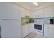 Well-lit kitchen with white cabinets, appliances, and a tiled backsplash offers a clean and efficient cooking space at 301 N Waccamaw Dr. # 209, Garden City Beach, SC 29576