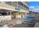 Exterior view of the shared pool area, surrounded by sun loungers and manicured landscaping at 301 N Waccamaw Dr. # 209, Garden City Beach, SC 29576