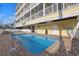 Inviting private swimming pool for residents, surrounded by brick pavers and conveniently located near the building at 301 N Waccamaw Dr. # 209, Garden City Beach, SC 29576