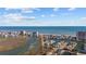 Scenic aerial view showcases beachfront homes and buildings along a waterway with a backdrop of the ocean under a partly cloudy sky at 310 37Th Ave. N, North Myrtle Beach, SC 29582
