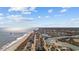 Wide aerial view of a coastal community featuring a beach, ocean, buildings, and marshland under a partly cloudy, sunny sky at 310 37Th Ave. N, North Myrtle Beach, SC 29582