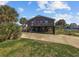 Inviting raised beach house with a red door, spacious driveway, and lush tropical landscaping at 310 37Th Ave. N, North Myrtle Beach, SC 29582