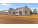 Gray brick house with screened in porch and well-manicured lawn awaiting landscaping at 3329 Hughes Gasque Rd., Aynor, SC 29511