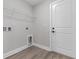 Bright laundry room with storage shelf, door to exterior, and wood-look flooring at 3329 Hughes Gasque Rd., Aynor, SC 29511