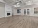 Spacious living room features a fireplace, windows, doors to the yard, and luxury vinyl flooring at 3329 Hughes Gasque Rd., Aynor, SC 29511