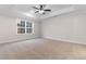 Carpeted main bedroom with tray ceiling, ceiling fan, and a large window at 3329 Hughes Gasque Rd., Aynor, SC 29511