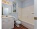 Bright bathroom with white vanity, a tub with shower, and wood floors at 3604 Brampton Dr., Myrtle Beach, SC 29588