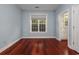 This bedroom offers hardwood floors, blue walls, and a large window for great natural light at 3604 Brampton Dr., Myrtle Beach, SC 29588