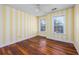 Bright bedroom with striped wallpaper, hardwood floors, and two windows for ample light at 3604 Brampton Dr., Myrtle Beach, SC 29588