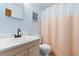 Cozy bathroom featuring a toilet, shower with a peach shower curtain, and sink at 405 21St Ave. S # 2H, North Myrtle Beach, SC 29582