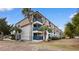 Coastal condo building with blue railings on balconies and palm trees in a landscaped yard under a bright sky at 405 21St Ave. S # 2H, North Myrtle Beach, SC 29582