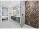Contemporary bathroom featuring a shower with unique tilework, a glass enclosure, and double vanities at 5368 Ocean Village Dr., Myrtle Beach, SC 29577