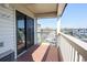 View of the parking area from the balcony, with wooden floors and white railing at 5601 N Ocean Blvd. # B306, Myrtle Beach, SC 29577