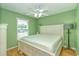Airy bedroom boasting pale green walls, complemented by a crisp white bed frame and gleaming hardwood floors at 6001 - 1527 S Kings Hwy., Myrtle Beach, SC 29575