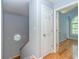 Upstairs hallway with hardwood floors, a six panel door and a unique octagonal window on the stairway at 6001 - 1527 S Kings Hwy., Myrtle Beach, SC 29575